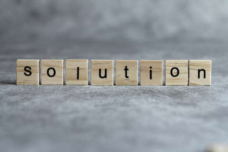 Solution word written on wood cube with gray background.の写真素材