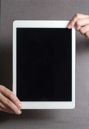 Hands showing tablet. A tablet is a wireless touch screen personal computer that is smaller than a notebook but larger than a smartphone.の写真素材