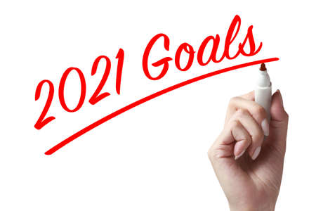 Hand holding a pen and writing 2021 goals, wish you all the best as always in this coming new year.の写真素材