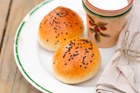 Bread Rolls with Black Sesame Seeds and a Cup of Milkの写真素材