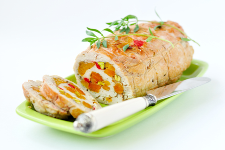 Baked turkey roll stuffed with dried apricots, cherries and pistachiosの写真素材
