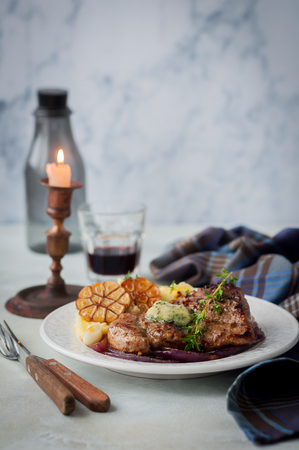 A Piece of Fried Pork Topped with Melting Herb Butter, Mashed Potatoes, Roasted Garlic, copy space for your textの写真素材