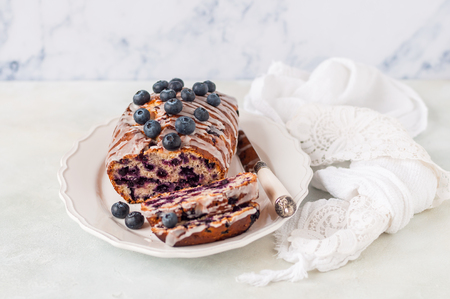 Healthy Blueberry and Oat Loaf Cake Topped with Icing Sugar Glaze and Fresh Berries, copy space for your textの写真素材
