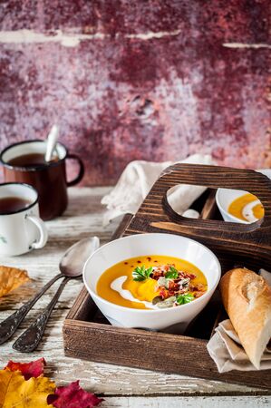 Roasted Pumpkin Cream Soup Garnished with Bacon, Pepitas and Parsley, copy space for your textの写真素材