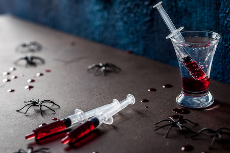 Creepy Halloween Party Cocktail with Syringes of Grenadine Syrup as Blood, copy space for your textの写真素材