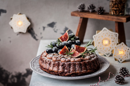 Chocolate Christmas Cake Decorated with Figs, Grapes, Walnuts and Rosemary