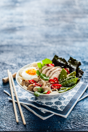 Chicken Ramen Soup Bowl over Blue Concrete Background, copy space for your textの写真素材