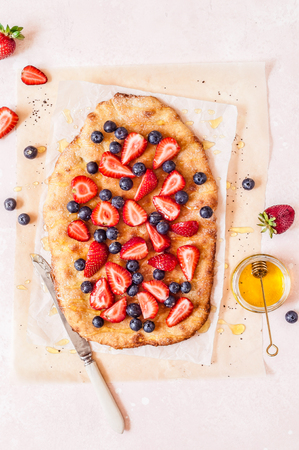Summer Flatbread with Fresh Strawberries, Blueberries and Honey, Colors of American Flag for Independence Day 4th July, copy space for your textの写真素材