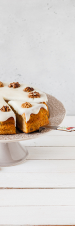 Sliced Pumpkin Cake with Walnuts and Cream Cheese Frosting, banner, copy space for text