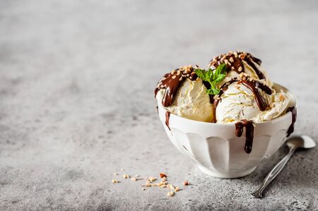 Vanilla Ice Cream Scoops with Chocolate Ganache and Chopped Nut Topping, copy space for your textの写真素材