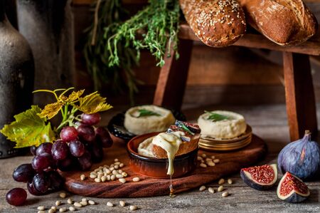 Soft Spreadable French Stinky Cheese on a Slice of Bread with Fruit and Pine Nutsの写真素材