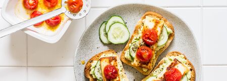Avocado, Fried Cheese, Fresh Cucumber and Roasted Tomato Toasts, bannerの写真素材