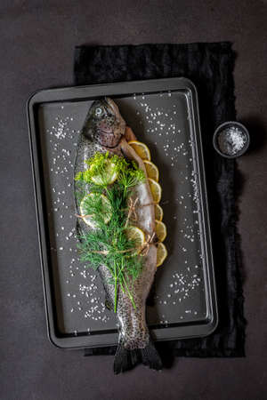 Whole Raw Trout / Salmon with Lemon and Dill on the Baking Tray Prepared to Be Roasted