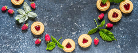 Shortbread Butter Cookies with Raspberry Jam Filling Center, Fresh Berries and Leaves, Blue Concrete...