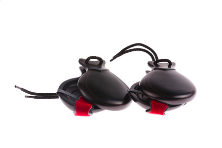 Pair of traditional hardwood Spanish castanets used as a musical accompaniment in flamenco and folk dancing muted with red tape isolated on a white backgroundの写真素材