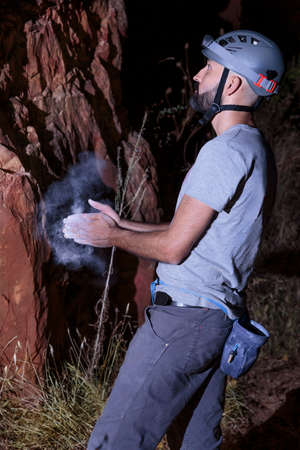 Hispanic male climber coating his hands in powder chalkの写真素材
