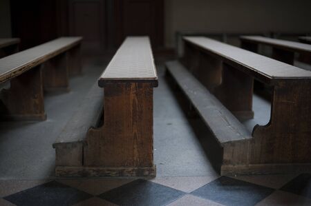 Old church wooden benches with poor light in empty church in Zagrebの写真素材