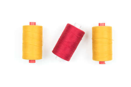 Yellow thread coils on white background, sewing and tailoring supplies