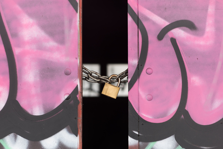 Pink doors closed with gold lock and chain. Warehouse entrance