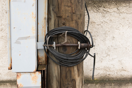 Wooden electric pole with wires and grey metal junction boxの写真素材