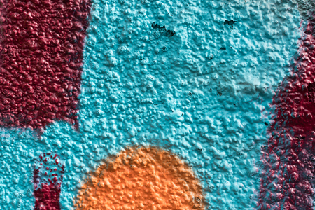 Orange and red graffiti details on a blue painted wall, facade. Abstract background, wallpaper.の写真素材
