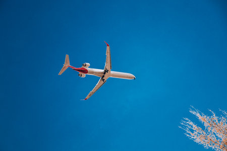 Passenger plane in flight. Bottom view of a red passenger plane flying above the clouds.のeditorial素材