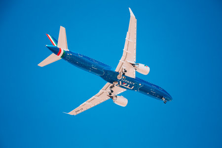 Low flying blue plane with white wings Airplane landing. Airplane on a blue isolated background....