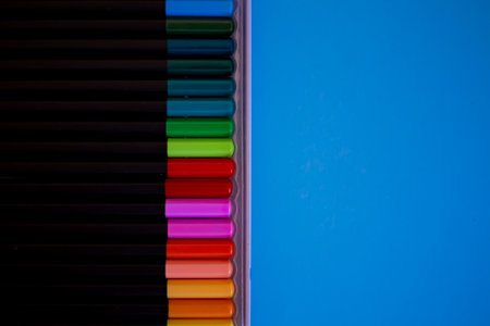 Art drawing for children. Drawing courses for children. Set of colored pencils arranged evenly on an blue background. Colored pencils are arranged exactly in a row.の写真素材