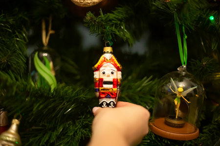 Hands decorating christmas tree with stylish bauble in atmospheric festive room. Merry Christmas. Winter holidays preparation.の写真素材