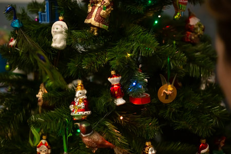Decorating Christmas tree, close up, copy space. Merry Christmas and Happy New Year. Women hands decorate the Christmas tree with balls and toys.の写真素材
