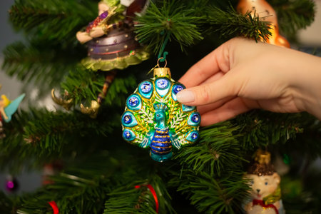 Decorating Christmas tree, close up, copy space. Merry Christmas and Happy New Year. Women hands decorate the Christmas tree with balls and toys.の写真素材