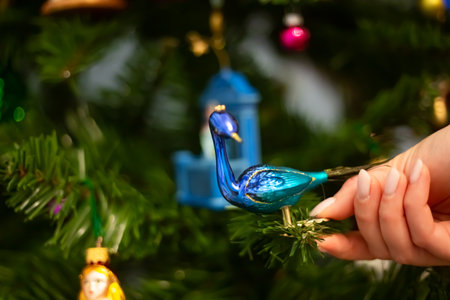 Decorating Christmas tree, close up, copy space. Merry Christmas and Happy New Year. Women hands decorate the Christmas tree with balls and toys.の写真素材