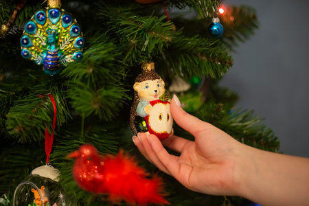 Decorating Christmas tree, close up, copy space. Merry Christmas and Happy New Year. Women hands decorate the Christmas tree with balls and toys.の写真素材