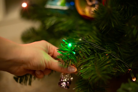 Decorating Christmas tree, close up, copy space. Merry Christmas and Happy New Year. Women hands decorate the Christmas tree with balls and toys.の写真素材
