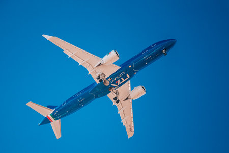 Italy, Lombardy, Milan 1.12.2023. Airplane against blue sky. The plane lands at the Italian airport Linateのeditorial素材