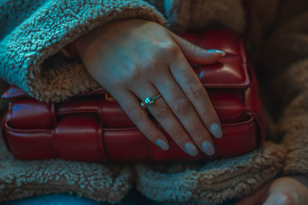 Milan, Italy - December, 17, 2023 Woman wears leather red mini Bottega Veneta Cassette bag, street style details.のeditorial素材