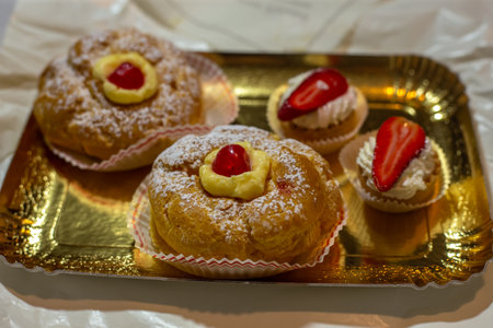 Italian dessert Zeppole di San Giuseppe, zeppola baked puffs made from choux pastry, filled and...