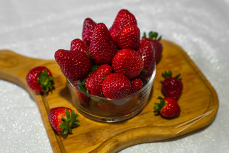 Fresh strawberries in a bowl on the tableの写真素材