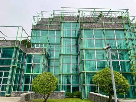 Glass green facade of office building. Milan, Italy