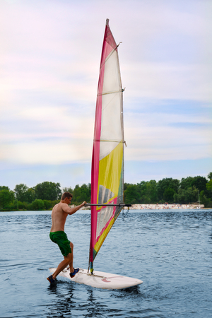 man stands on the Board in the water windsurfingの写真素材