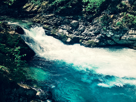 blue transparent mountain stream among rocks and stonesの写真素材