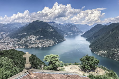 Mountain blue lake. The water surface on the lake among the mountains. Tile roof with a stone cross over the lakeの写真素材