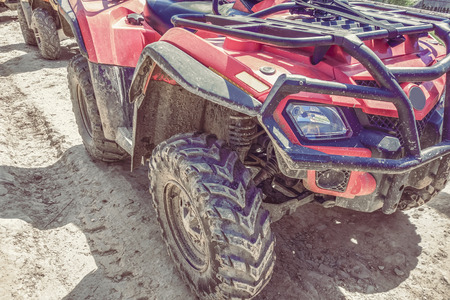 red quad bike on a dirt road, close-up, side and front view