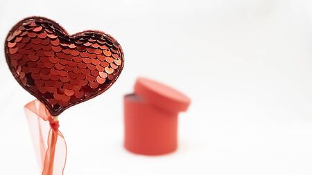 Red heart sequins and red gift box cylindrical shape on a white background for Valentines day, copy space の写真素材