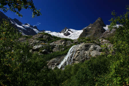 Waterfalls and glaciers and green valleys. Exotic picture - ice, water, forest, summer in one paletteの写真素材