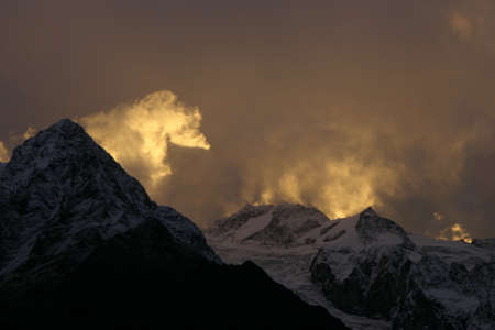 Cloudy red sunset in the mountainsの写真素材