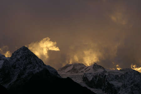 Cloudy red sunset in the mountainsの写真素材