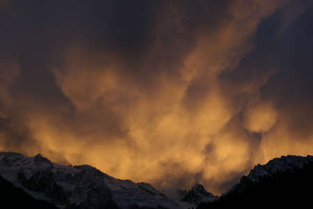 Cloudy red sunset in the mountainsの写真素材