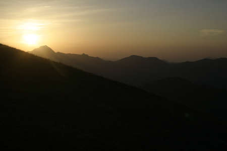 Cloudy red sunset in the mountainsの写真素材