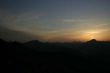 Cloudy red sunset in the mountainsの写真素材